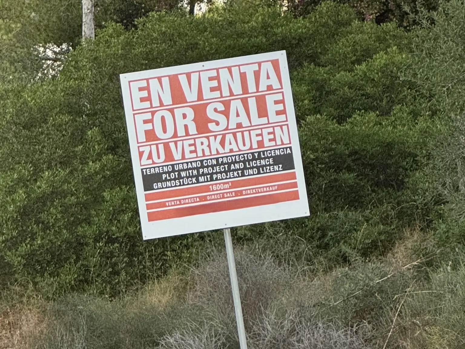 Sale sign in Spanish, English and German on a building plot in Calvià: 1,600 m² with project and licence, direct sale